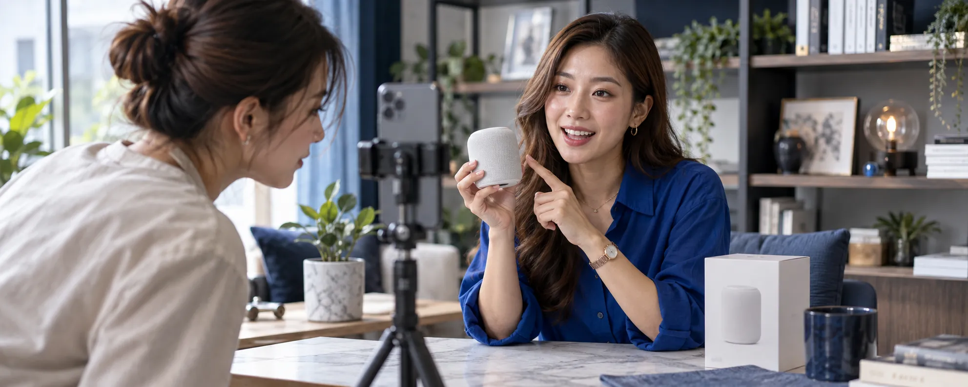 A lifestyle creator filming a speaker review on a smartphone with a campaign partner